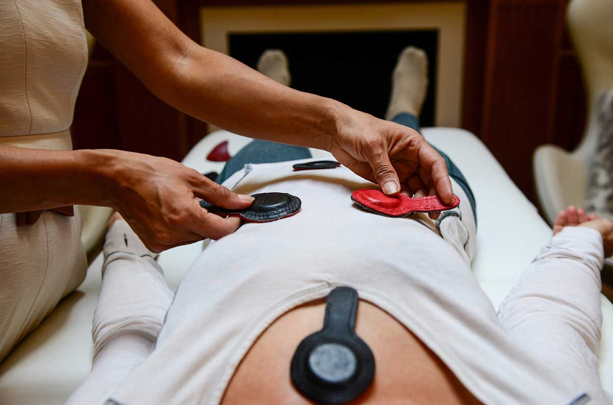 terapeuta de biomagnetismo aplicando imanes a un paciente